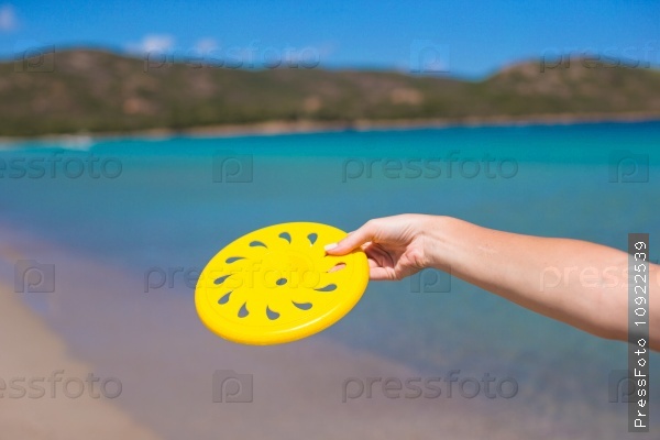 Close-up of yellow frisbee on the background of turquoise sea, stock photo