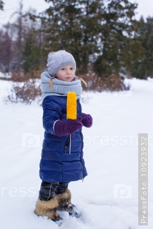 Little girl with sweet corn at winter park
