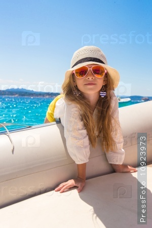 Cute little girl enjoying sailing on boat in the open sea