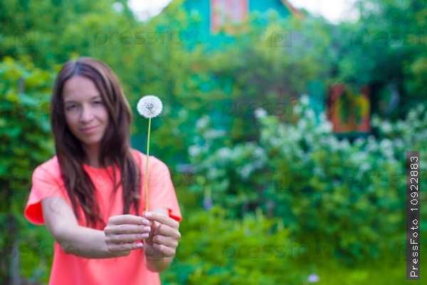 Young woman with dandelions in hands outdoors