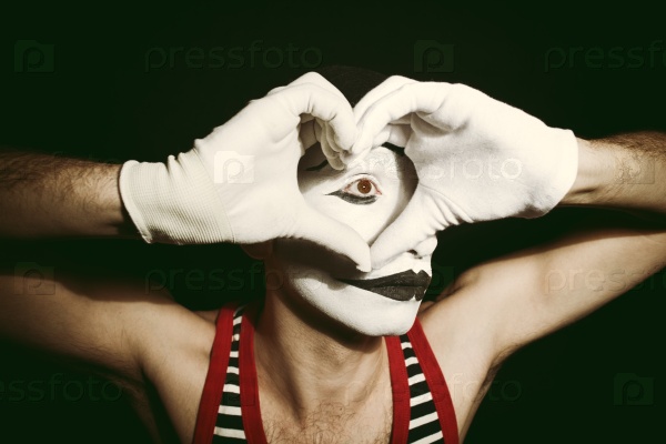 Portrait of sad mime with heart on black background, stock photo