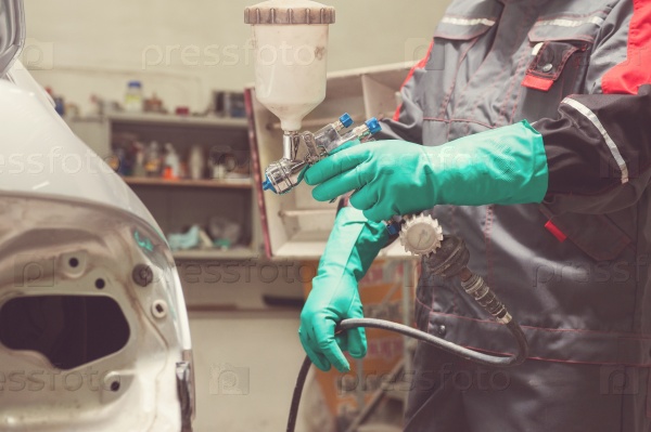 Spray gun with paint for painting a car , stock photo