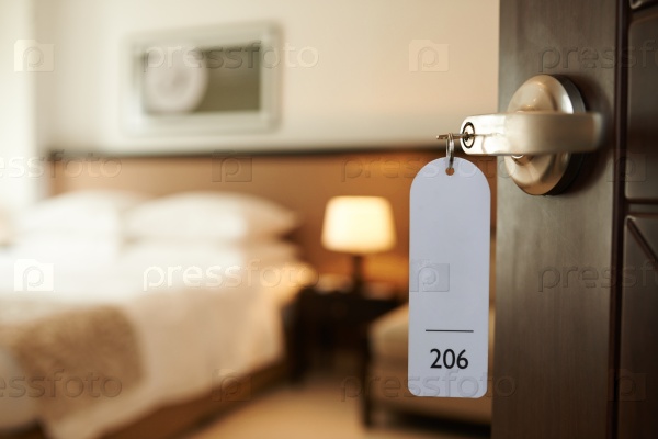 Opened door of hotel room with key in the lock