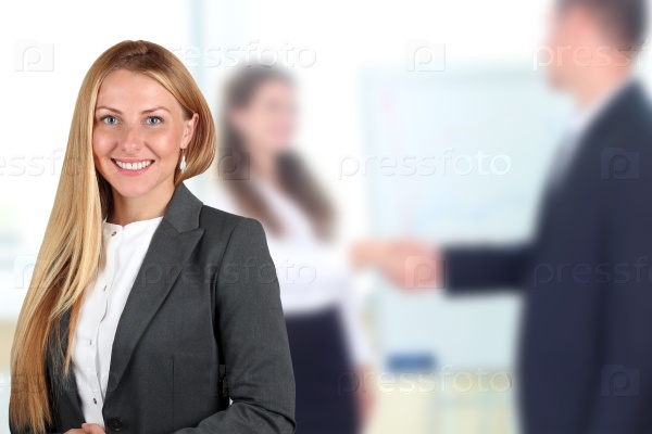 The Beautiful smiling business woman  portrait. handshake between two colleagues behind