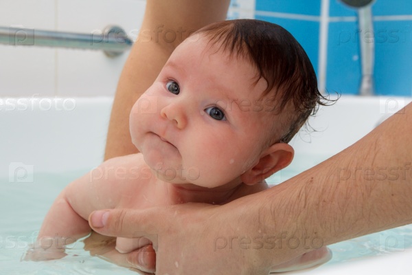 Newborn baby bathe and swim in a large tub, stock photo
