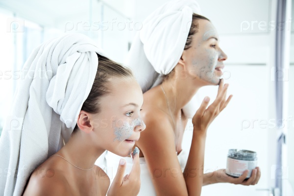 Mother and tween daughter make a clay facial mask, family skin care in the bathroom