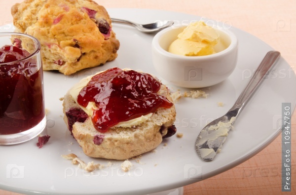 British scone with strawberry jam and butter on a cake stand, stock photo