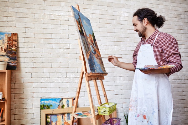Professional artist painting a picture on canvas