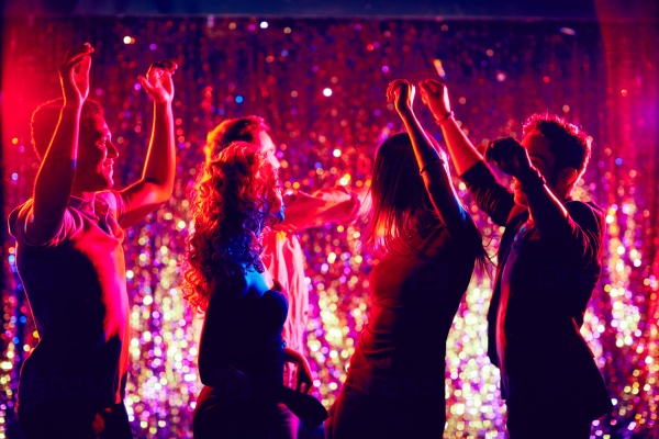 Group of people dancing in disco club to the music