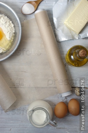 Ingredients for the pancakes on the white wooden table around the parchment roll