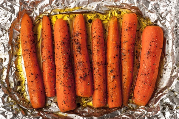 Baked carrots with black pepper on a sheet of foil top view