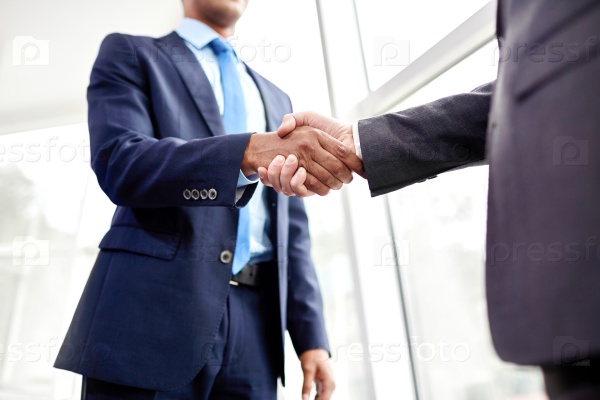 Handshake of two business people in the office, stock photo