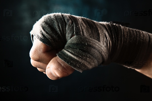 Close-up hand with bandage of muscular man training kickboxing on black , stock photo