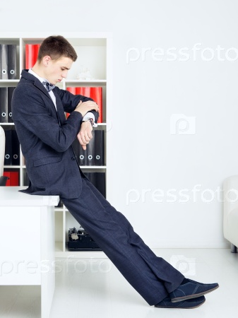 handsome businessman looking at watch in his office