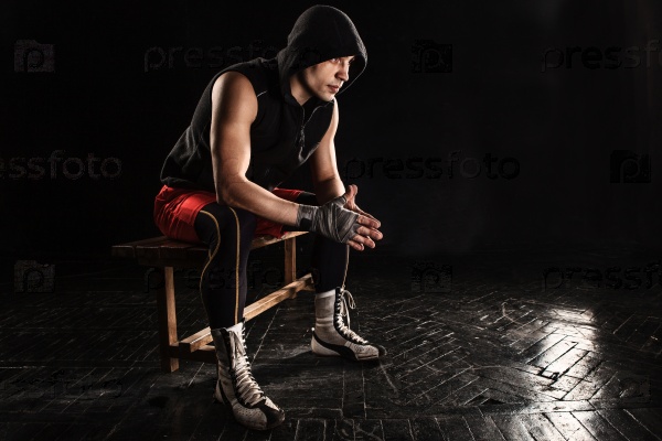 The muscular boxer sitting and resting on black, stock photo