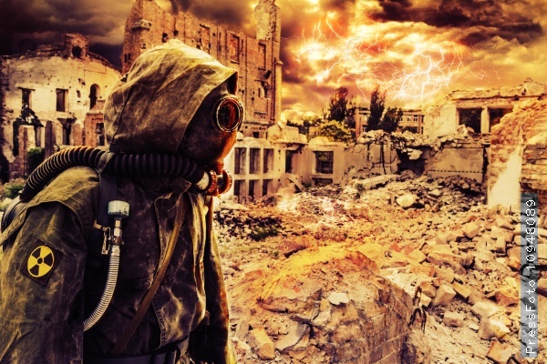 Post apocalypse. Sole survivor in tatters and gas mask on the ruins of the destroyed city, stock photo