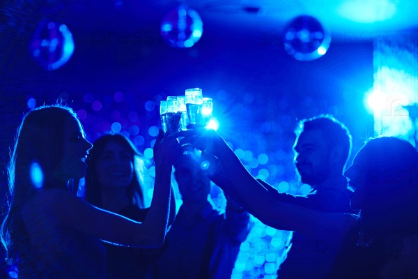 Group of happy friends toasting at party in night club, stock photo