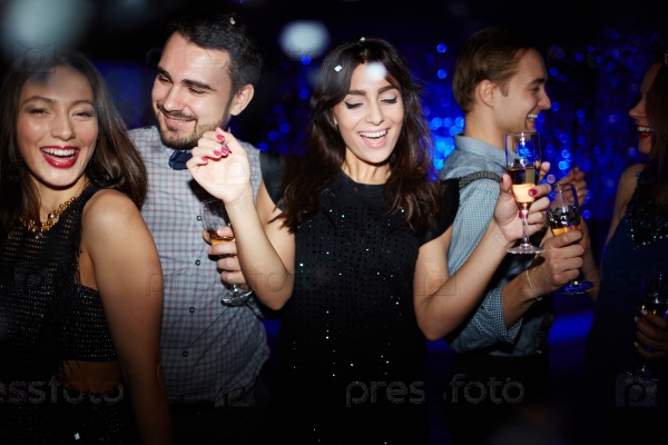 Group of happy friends dancing at night party, stock photo