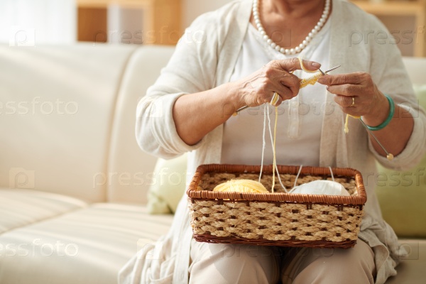 Cropped image of grandmother knitting at home
