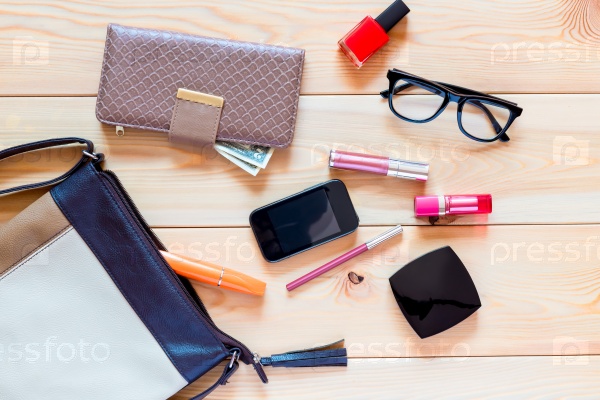 The contents of women\'s handbags are scattered on the floor, stock photo