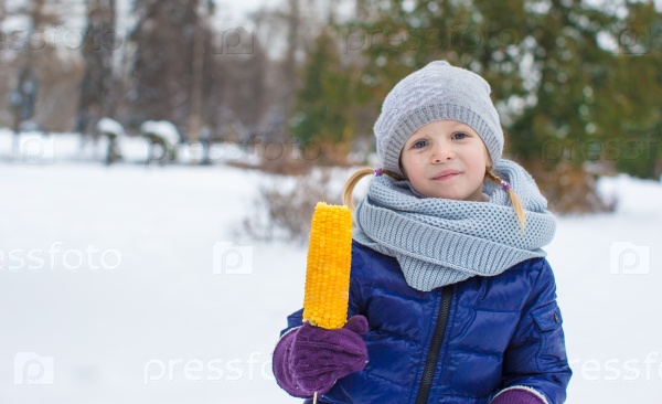 Little girl with sweet corn at winter park