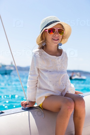 Little girl enjoying sailing on boat in the open sea