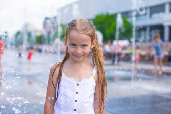 Little girl have fun in outdoor fountain at hot day