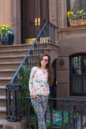 Young woman walking near old houses in historic district of West Village