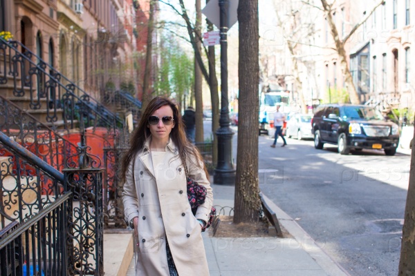Young woman walking near old houses in historic district of West Village