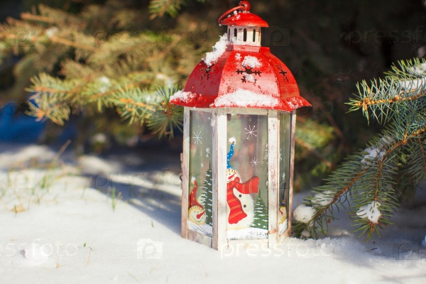 Decorative Christmas lantern near fir branch in snow winter day