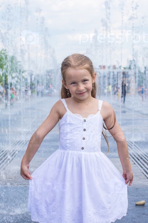 Little cute girl have fun in open street fountain