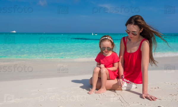 Mother and daughter relaxing at tropical beach