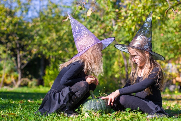 Little girls casting a spell on Halloween in witch costume