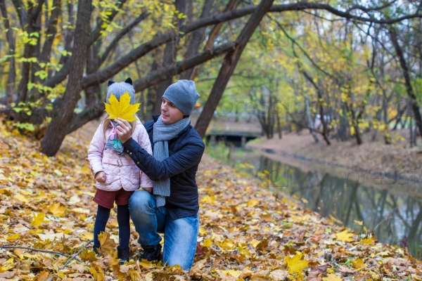 Little girl and happy dad in autumn park outdoors