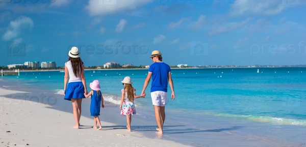 Back view of happy family on tropical beach