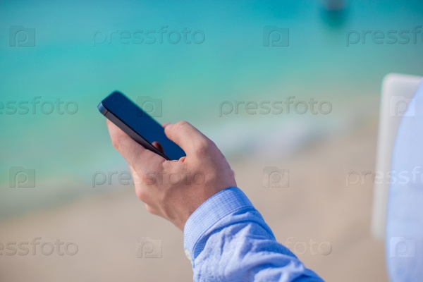 Close up telephone on the background of computer on the beach, stock photo
