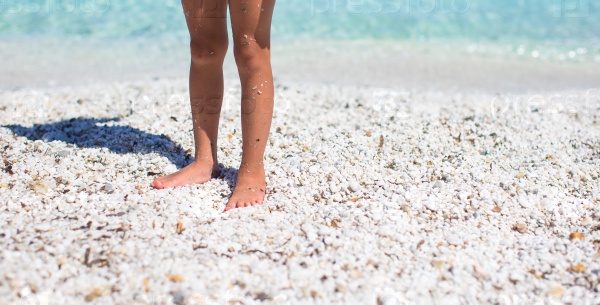 Close up of a little girl feet on tropical sandy beach, stock photo