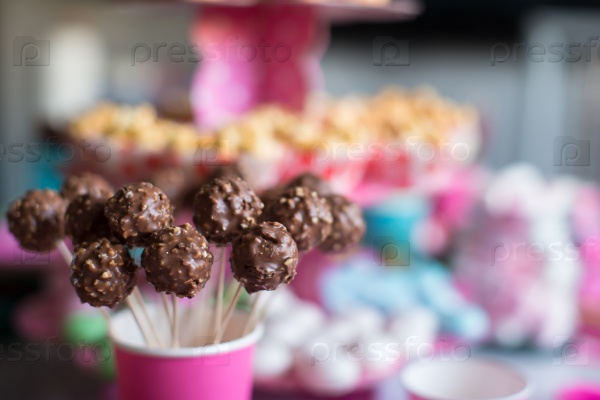 Tasty cakepops on holiday dessert table at kid birthday party, stock photo