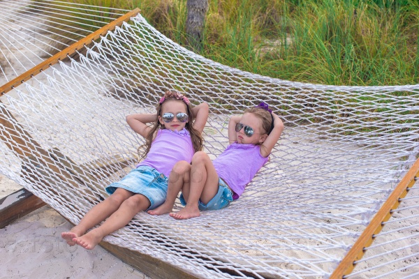 Little sweet girls relaxing in hammock on summer vacation