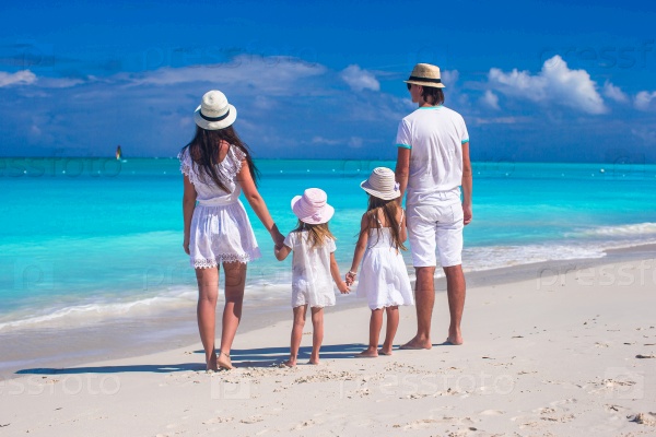 Back view of young family with two kids on caribbean vacation