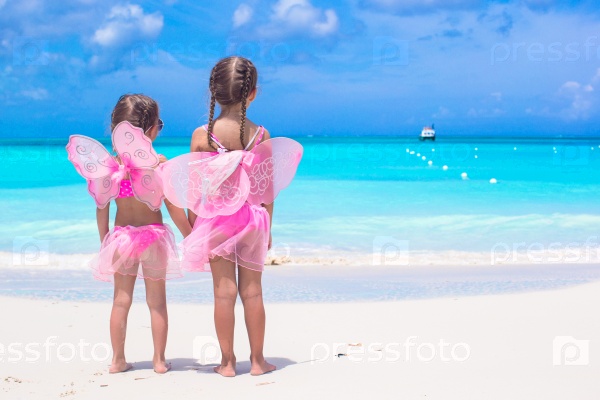Little girls with butterfly wings on beach summer vacation