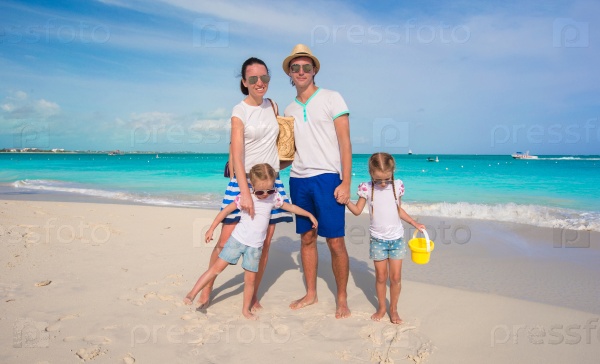 Happy family of four on beach tropical vacation