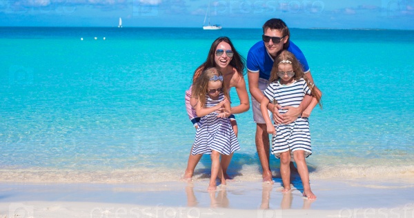 Happy family of four on beach vacation