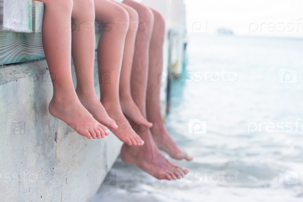 Close up hanging their legs into the water on the wooden pier, stock photo