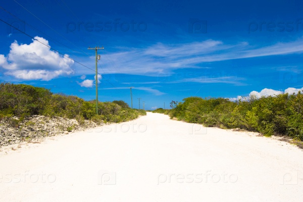 Deserted tropical road with white sand on the Caribbean island, stock photo