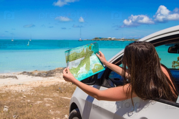 Young attractive woman with great map of island in the car