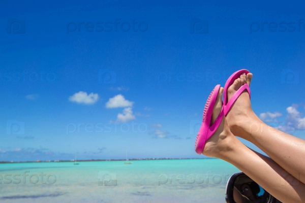 Flip Flops from the window of a car on background tropical beach