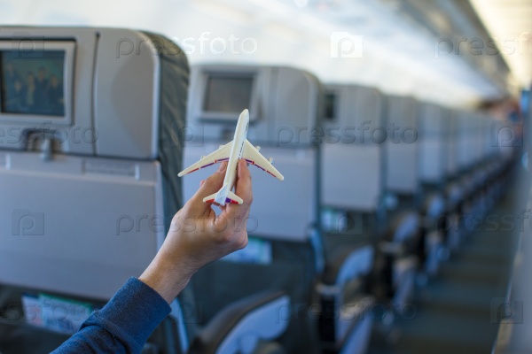 Close up hand holding an airplane model inside a large aircraft, stock photo