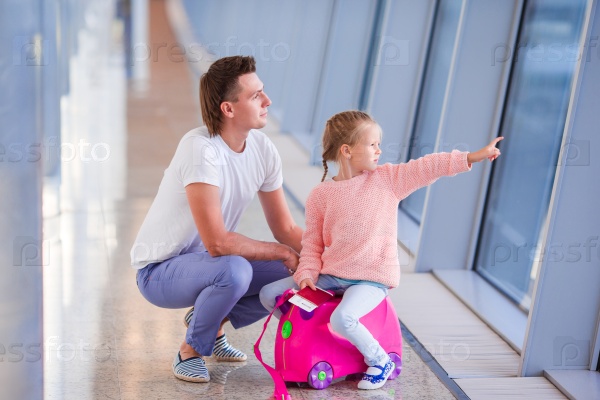 Happy family with luggage and boarding pass at airport waiting for boarding, stock photo