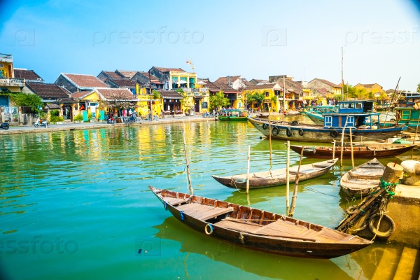 Traditional boats in front of ancient architecture in Hoi An, Vietnam. Hoi An is the World\'s Cultural heritage site, famous for mixed cultures & architecture.